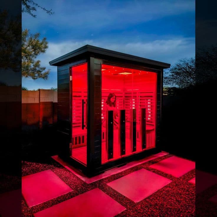 Cabine de sauna com fotobiomodulação LED vermelha ativa, vista externa ao entardecer